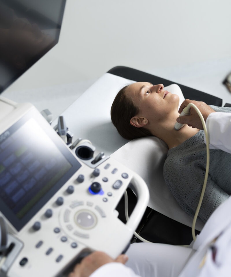 Der Arzt untersucht die Schilddrüse an Hals einer Patientin