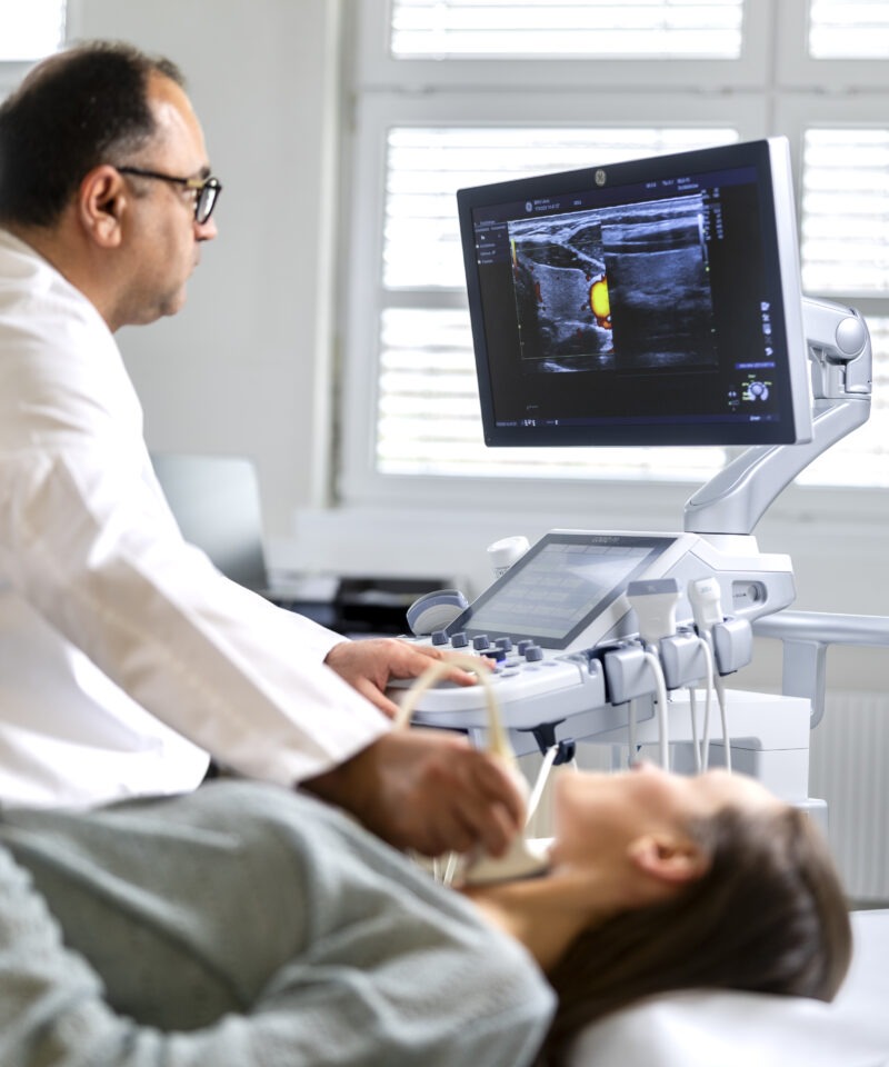 Der Arzt untersucht die Schilddrüse an Hals einer Patientin