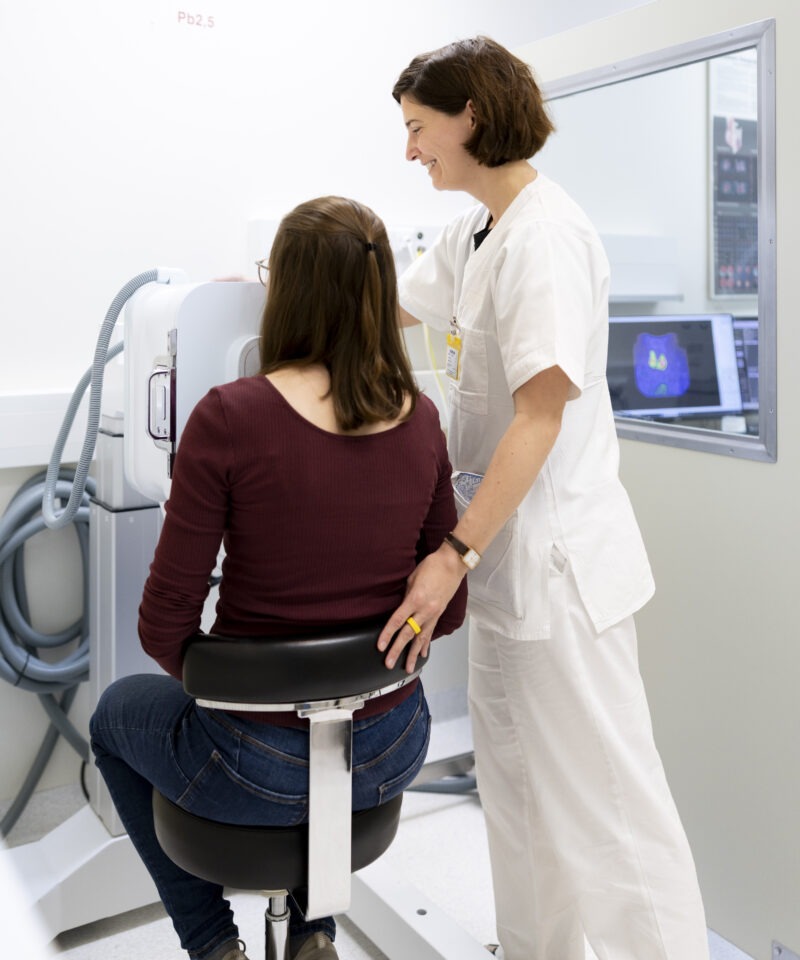die Radiologietechnologin unterstützt die Patientin während der Untersuchung bei der Gammakamera