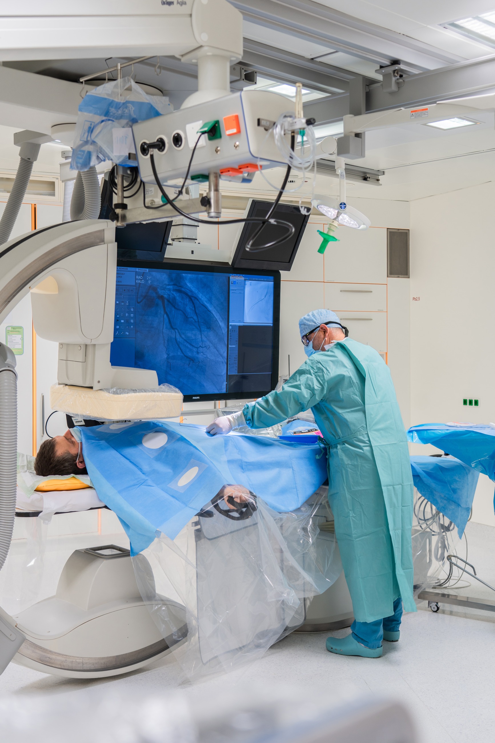 Die Pflegekraft bereitet den Patienten für den Eingriff im Herzkatheterlabor vor