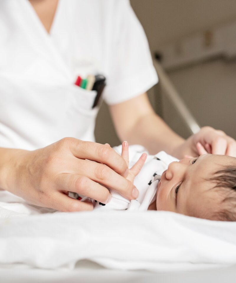 die Hebamme macht die erste Gewichtsmessung beim Baby